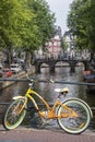 Yellow and green bike with buildings and old bridge