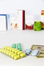 Yellow green blue medical pills and american dollars on white background Royalty Free Stock Photo