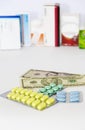 Yellow green blue medical pills and american dollars on white background Royalty Free Stock Photo