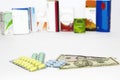 Yellow green blue medical pills and american dollars on white background Royalty Free Stock Photo