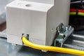 Yellow and green ground wire connected to the electrical socket mounted on DIN rail close-up. Electrical appliance grounding