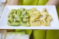 Yellow and green kiwi sliced on dish