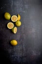 yellow and green lemons, cut and uncut, on a background of dark, black, cement, metallic, marble and stone Royalty Free Stock Photo