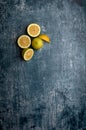 yellow and green lemons, cut and uncut, on a blue, dark, metallic, cement, marble, stone background Royalty Free Stock Photo