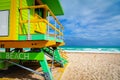 Yellow and green lifeguard tower in South Beach under a cloudy sky