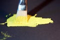 Yellow green oil paint freshly photographed from the tube for artists with brush on black background Royalty Free Stock Photo