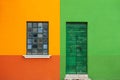 Yellow and green painted facade of the house with wooden door and window. Burano, Italy Royalty Free Stock Photo