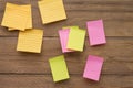 Yellow, green, pink reminder notes on a wooden board, empty space for text Royalty Free Stock Photo