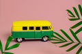 retro van among palm tropical leaves on a pastel pink background Royalty Free Stock Photo