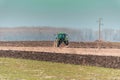 The yellow green tractor makes a deep plowing of the field