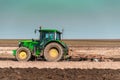 The yellow green tractor makes a deep plowing of the field