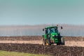 The yellow green tractor makes a deep plowing of the field