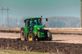 The yellow green tractor makes a deep plowing of the field