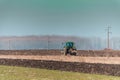 The yellow green tractor makes a deep plowing of the field