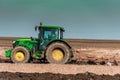 The yellow green tractor makes a deep plowing of the field