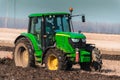 The yellow green tractor makes a deep plowing of the field