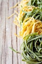 Yellow and green uncooked pasta tagliatelle Royalty Free Stock Photo