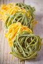 Yellow and green uncooked pasta tagliatelle Royalty Free Stock Photo