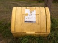 A yellow grit box outside with its lid closed and on the grass n Royalty Free Stock Photo
