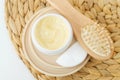 Yellow hair mask (banana face cream, shea butter mask, mango body butter) in a small white container and hairbrush. Royalty Free Stock Photo