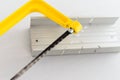 Yellow hand saw and aluminium miter box for hobby in home workshop Royalty Free Stock Photo
