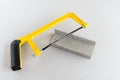 Yellow hand saw and aluminium miter box for hobby in home workshop Royalty Free Stock Photo