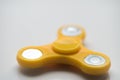 Yellow Hand Spiner. Stress relieving toy on white background. Close-up. Top view. Stock photo
