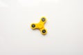 Yellow Hand Spiner. Stress relieving toy on white background. Close-up. Top view. Stock photo