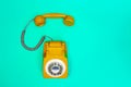 Yellow handset of a telephone on a green mint background. Royalty Free Stock Photo