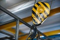 Yellow hanging crane in the workshop close-up Royalty Free Stock Photo