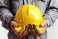 Yellow hard hat in the hands of a builder Isolated on solid white background Royalty Free Stock Photo