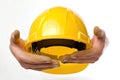 Yellow hard hat in the hands of a builder Isolated on solid white background Royalty Free Stock Photo