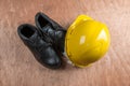 Yellow hard hat and leather boots, protective equipment in construction industry. Royalty Free Stock Photo