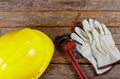 Yellow hard hat and leather work gloves and wrench construction Royalty Free Stock Photo