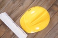 Yellow hard hat and a roll of drawings Royalty Free Stock Photo