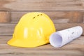 Yellow hard hat and rolled drawings for construction Royalty Free Stock Photo