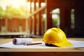 Yellow hard hat safty helmet and blueprint on a desk at construction site, engineering and construction industry concept. Royalty Free Stock Photo