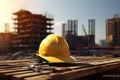 Yellow hard hat on a wooden table in front of a construction site Royalty Free Stock Photo