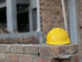 Yellow hard safety hat on construction site concept