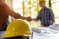 Construction Deal: Handshake and Yellow Hard Hat Royalty Free Stock Photo