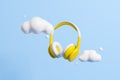 Yellow headphones and clouds on blue background