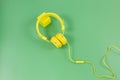 Yellow Headphones on a green background. Music concept.