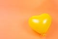 Yellow heart ballon on orange background