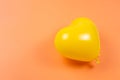 Yellow heart ballon on orange background