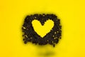 yellow heart in black shredded papers on yellow background, creative art design, minimal love concept, elegant idea