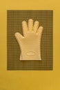 Yellow heat resistant glove on kitchen mesh mat