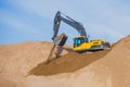 Yellow heavy excavator and bulldozer excavating sand and working during road works, unloading sand and road metal Royalty Free Stock Photo