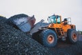 Yellow heavy excavator and bulldozer excavating sand and working during road works, unloading sand and road metal Royalty Free Stock Photo