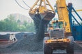 Yellow heavy excavator and bulldozer excavating sand and working during road works, unloading sand and road metal Royalty Free Stock Photo