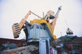 Yellow heavy excavator and bulldozer excavating sand and working during road works, unloading sand and road metal